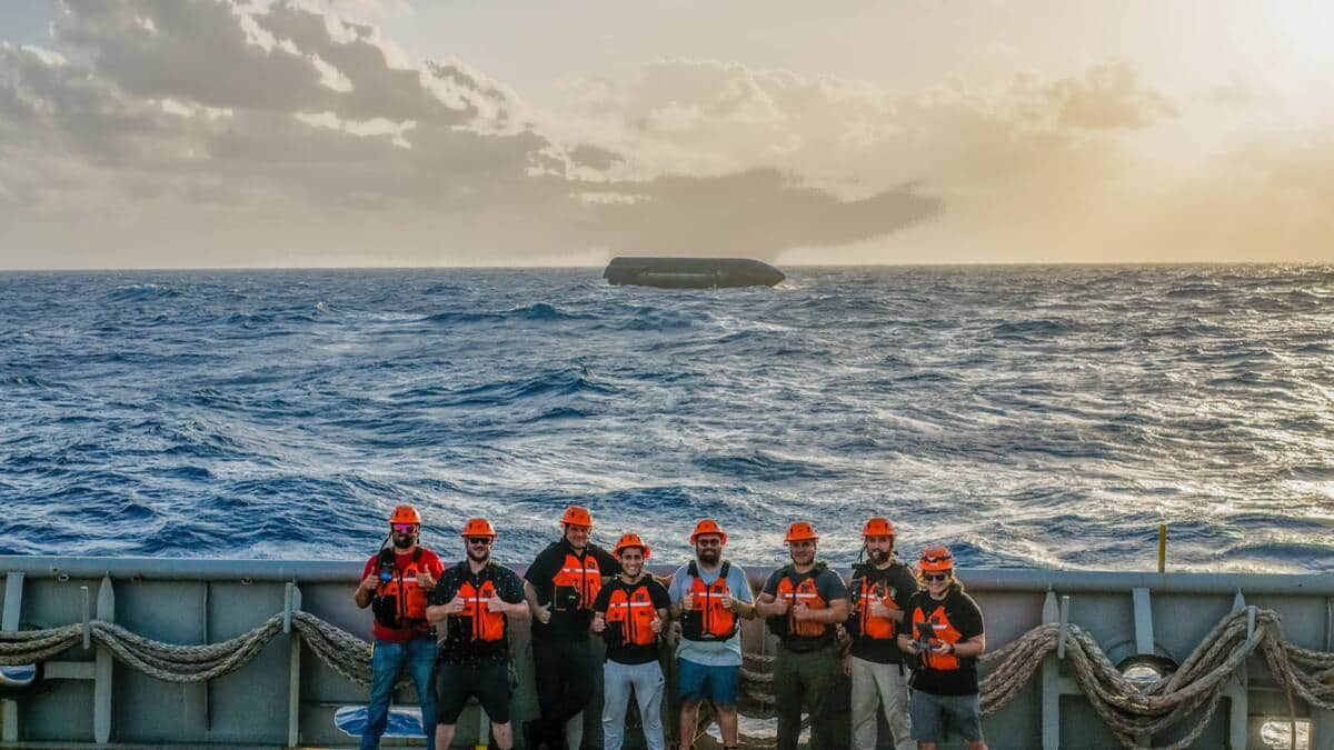 Un grupo de personas con chalecos salvavidas y cascos en la cubierta de un barco