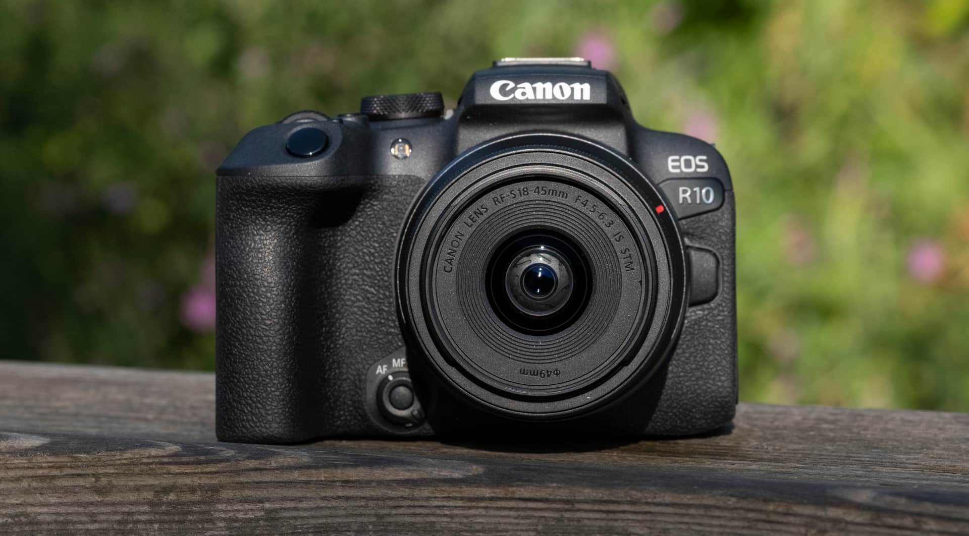 Canon EOS R10 camera sitting on a wooden bannister