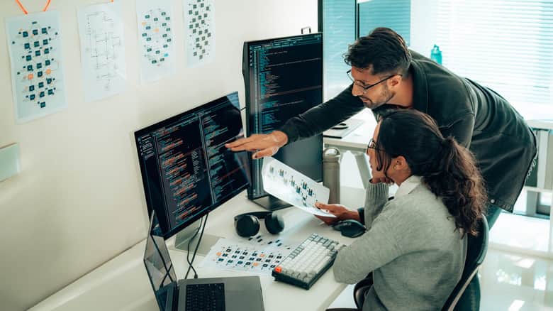 Programmers collaborating on software development in a modern office setting.
