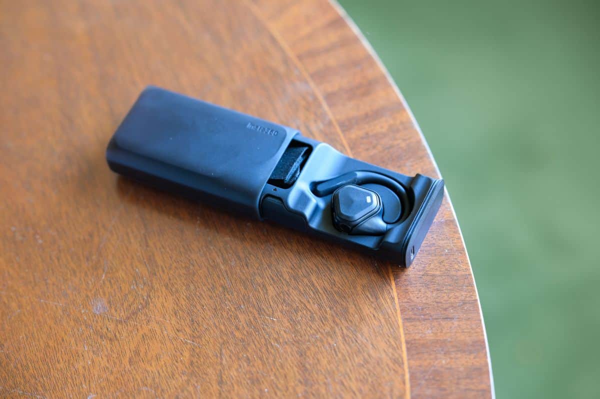 Insta360 POV Head Tracker accessory in its hard-shell battery case on a mahogany table
