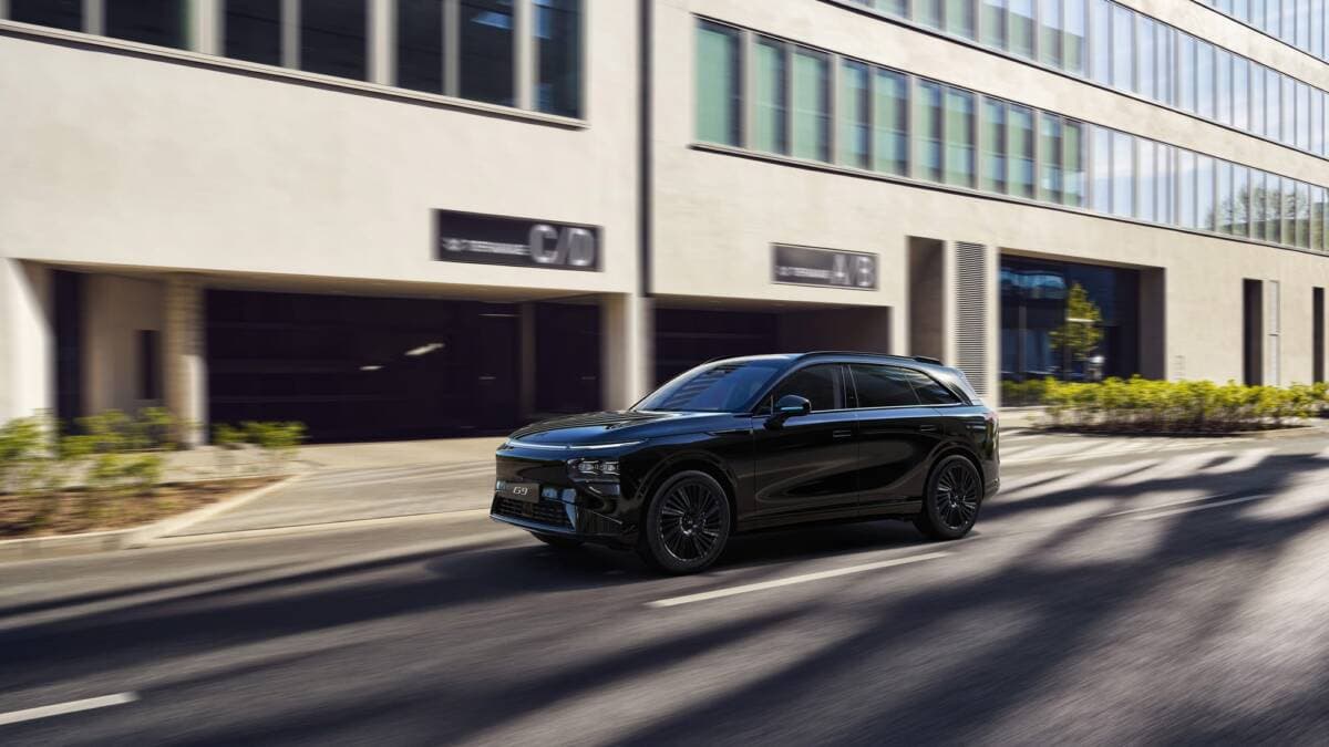 Black XPeng electric car on a street surrounded by urban architecture