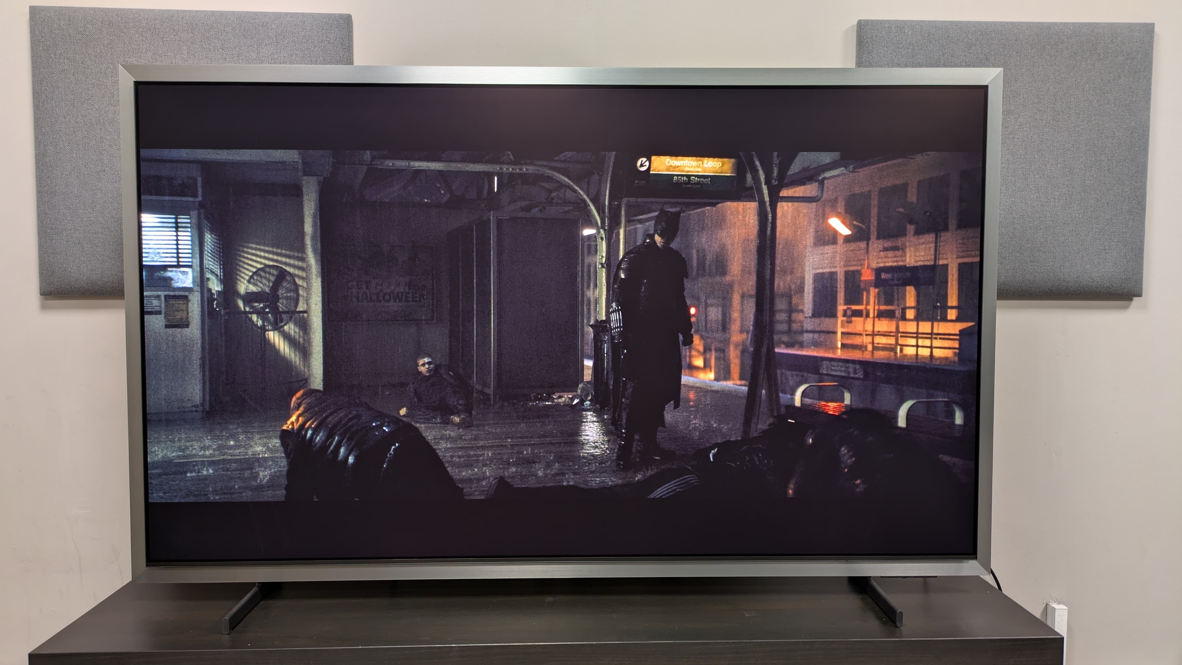Samsung S95H showing Batman on a subway platform in Movie mode under bright conditions