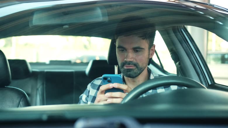A man using his phone in a car