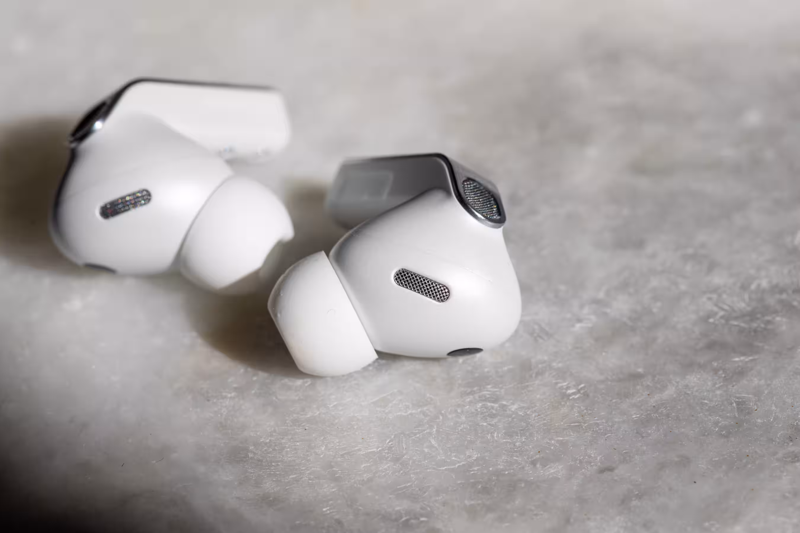 The Samsung Galaxy Buds 4 Pro earbuds on a white marble table.