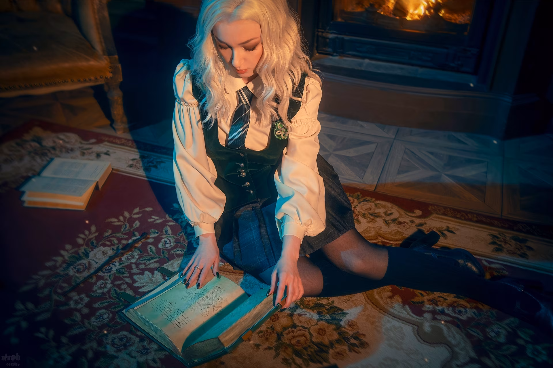 Girl in school uniform holding a book as a Slytherin student