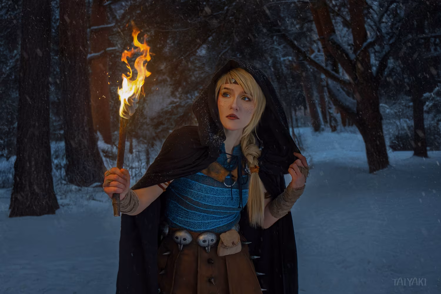 Woman dressed as witch holding torch