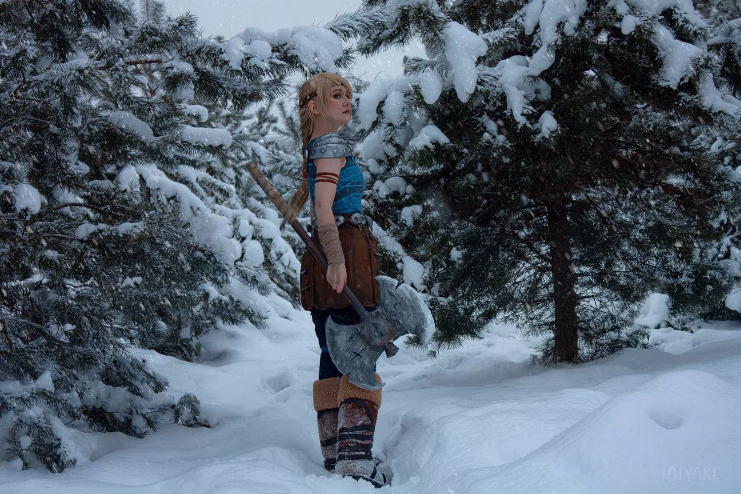Cosplay of Ariel from game with torch in snowy forest