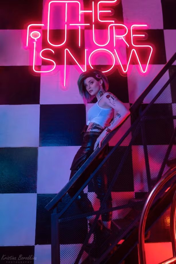 Woman posing near neon sign 'The Future is Snow'