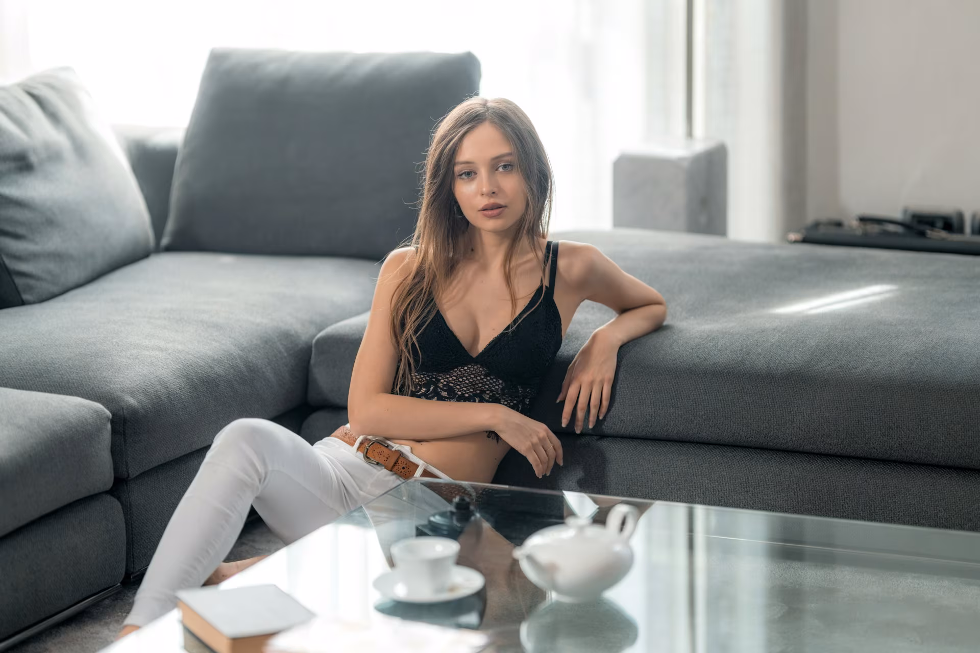 Woman on sofa in living room, M.Video air conditioners