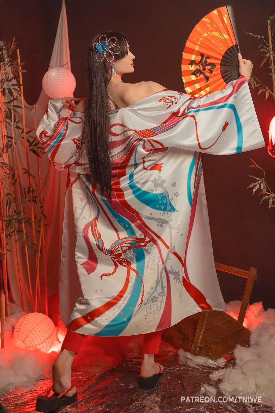 Model in a brightly designed kimono holding a fan