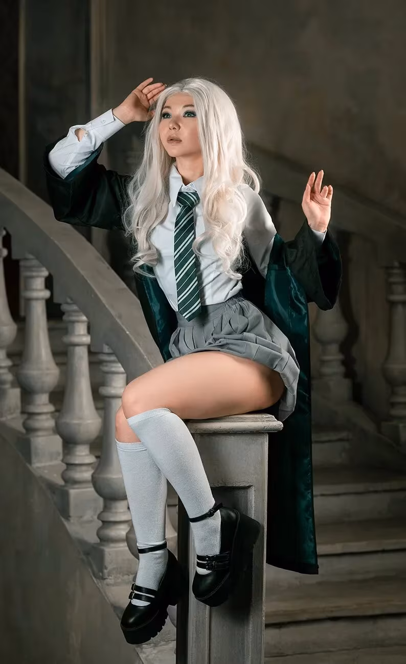 Model with long blonde hair in school uniform cosplay representing Slytherin and Ravenclaw