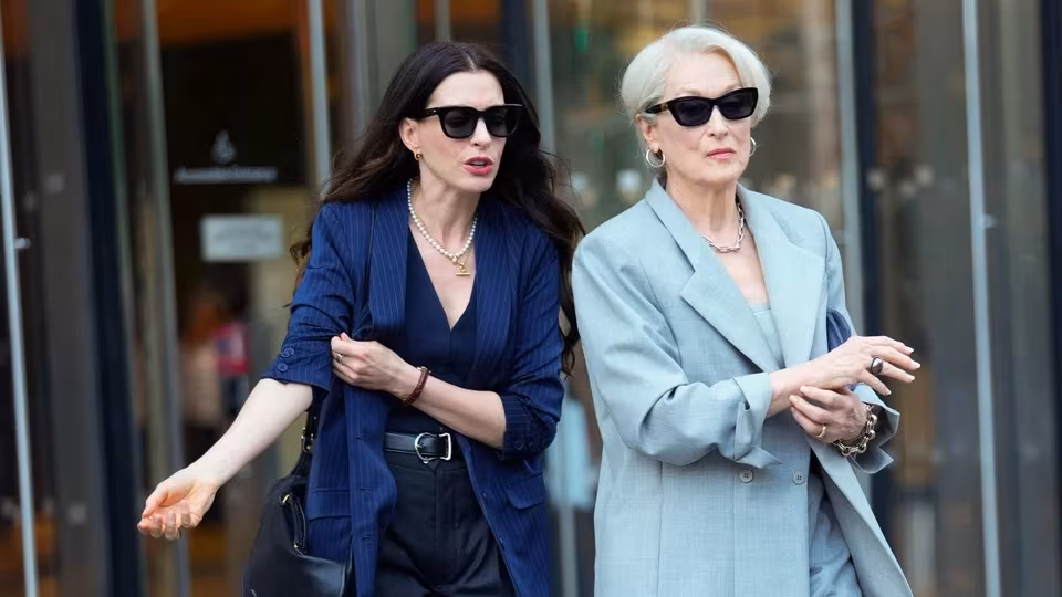 Two women in stylish suits and sunglasses