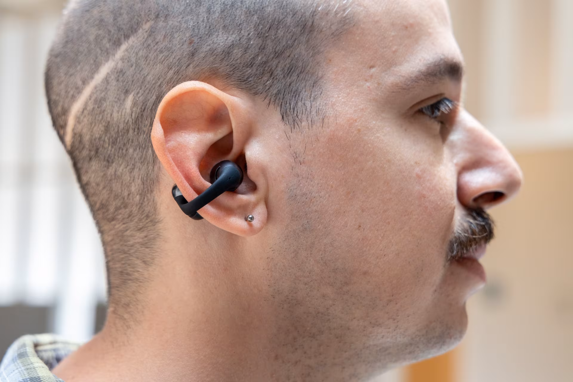 Person wearing Shokz OpenDots 2 headphones up close