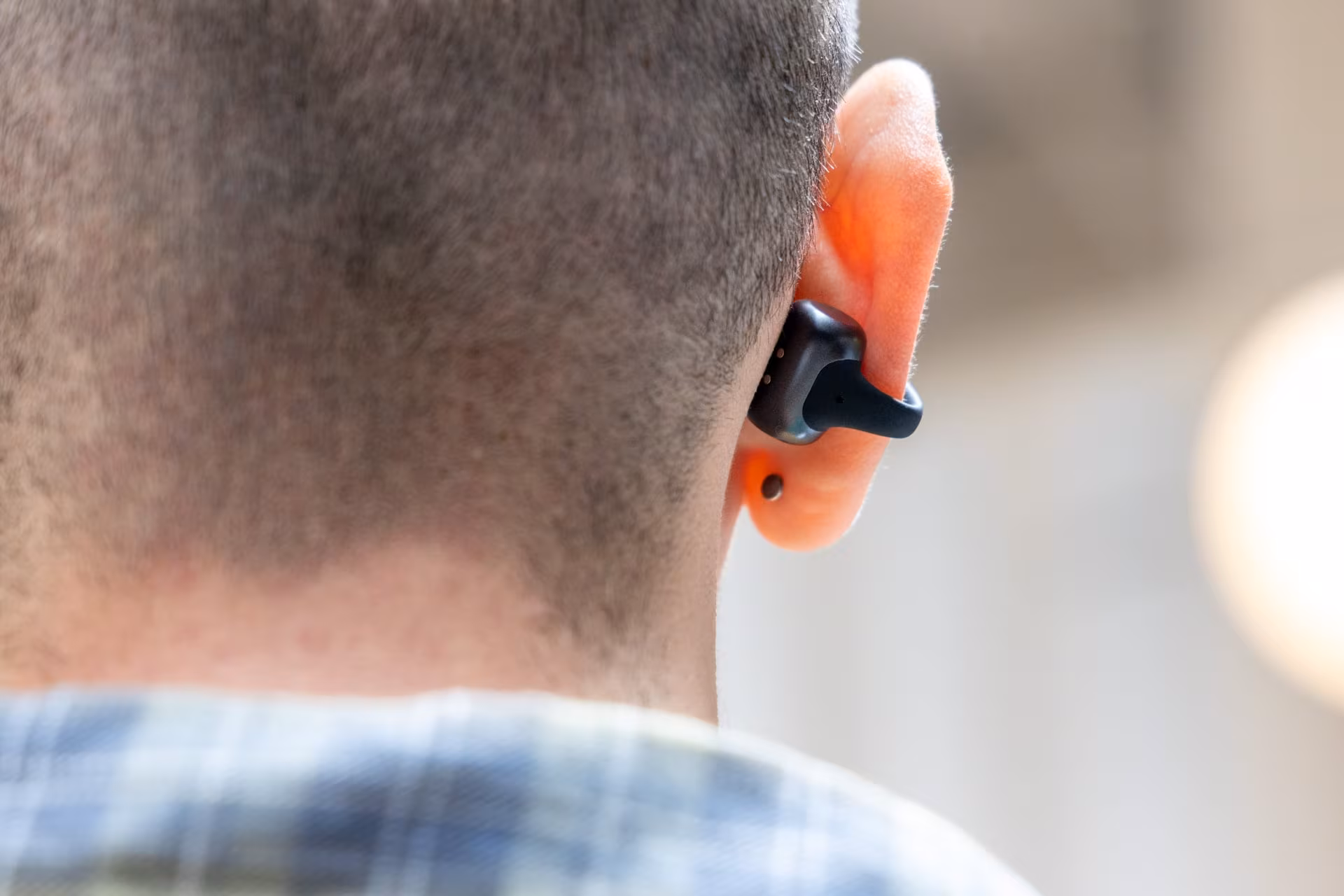 Close-up of person's ear wearing Shokz OpenDots 2 headphones