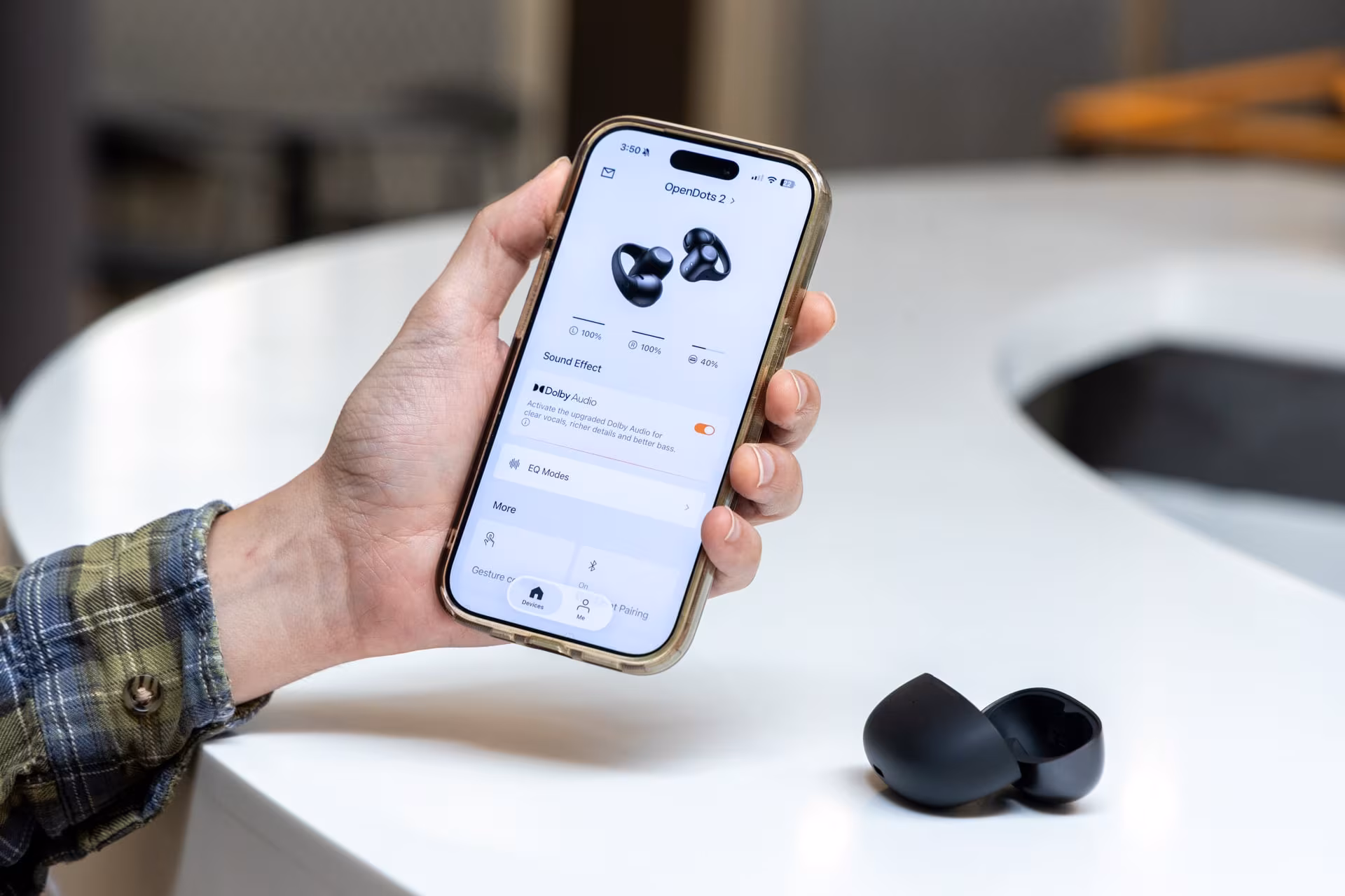 Person holding smartphone with Shokz OpenDots 2 app settings