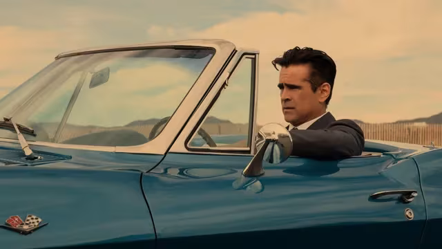 Man in suit driving classic car in Apple TV series